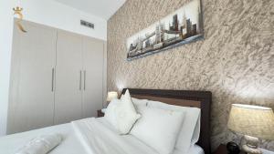 a bedroom with a bed with white sheets and pillows at Rodeo Retreat - Chic 1BR Apartment on Yas Island, 12 Min to Grand Prix in Abu Dhabi +36 photos