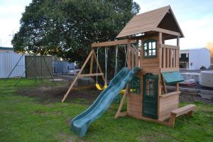 a wooden playground with a slide and a tower at Wattle Motel in Seymour