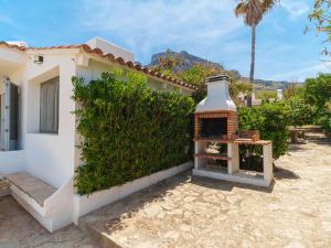 a building with a fireplace next to a yard at Holiday Home Xoroi by Interhome in Colonia de Sant Pere
