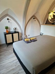 a large bed in a room with arched ceilings at La Chapelle du Coteau in Nomexy