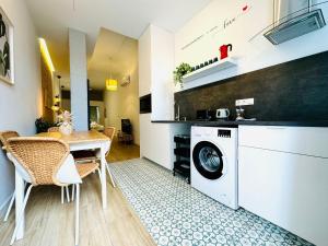 a kitchen and dining room with a washer and dryer at Dorado Cabanyal - Luxury Beachside Charm in Valencia