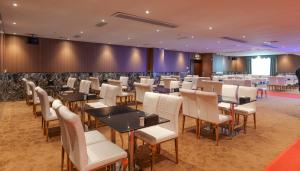 a restaurant with tables and chairs in a room at 家德里酒店Dilli home hotel in Zhongshan