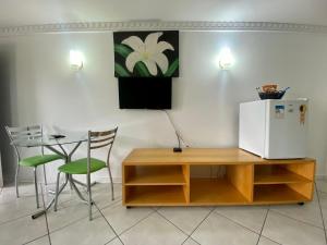 a kitchen with a table and a white refrigerator at Hotel San Bernardino in Guaramirim