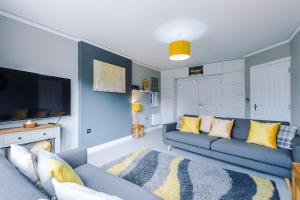 a living room with a blue couch and a tv at Grange House in Chester