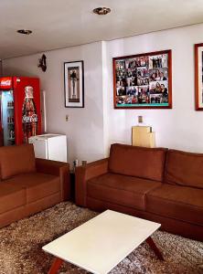 Sala de estar con 2 sofás marrones y mesa de centro en MAGA PLAZA HOTEL, en São José do Rio Pardo