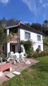 a white house with white chairs in front of it at Vikendica Nada in Ljubovija