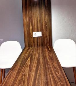 two white chairs and a wooden door with a sign on it at 40 m2 Confort apartament in Bălţi