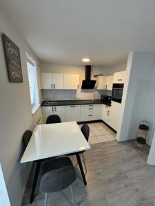 a small kitchen with a white table and chairs at Alex Apartments 3 in Solingen
