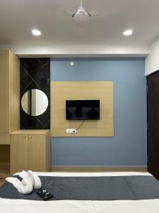 a room with a bed with a television and towels at Wildwings hotel in Hyderabad