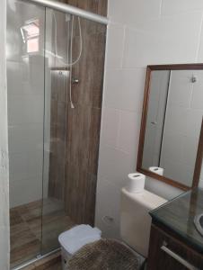 a bathroom with a shower and a toilet and a mirror at Pousada Habitacion Aurora 3 in São Gabriel