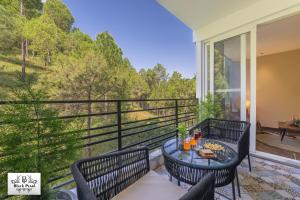 a patio with a table and chairs on a balcony at The BlackPearl Hillcrest in Kasauli