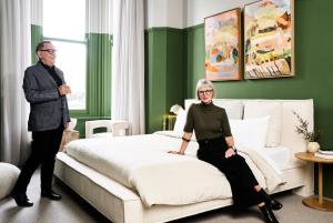 バララットにあるHotel Vera Ballaratのベッドの横に立っている男性と女性