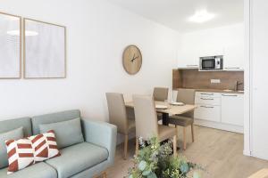 a living room with a couch and a table at OVELIA Angers - Les Jardins d'Arborescence in Angers