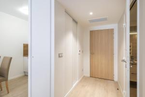 a hallway with a wooden door in a room at OVELIA Angers - Les Jardins d'Arborescence in Angers