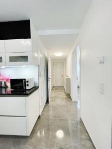 ギーセンにあるLuxury Wohnung mit Großem Bett und Schlafsofa Luxuriös Ausgestattet mit schöne Terrasse und Garten!の白いキャビネットと電子レンジを備えたキッチン