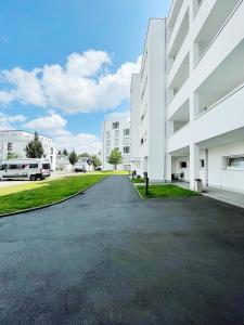 ギーセンにあるLuxury Wohnung mit Großem Bett und Schlafsofa Luxuriös Ausgestattet mit schöne Terrasse und Garten!の白い建物の前の空き道