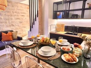 stół z talerzami jedzenia w kuchni w obiekcie Duplex High Standing 7'➤Fontainebleau⎮45'➤Paris + Terrace w mieście Veneux-les-Sablons