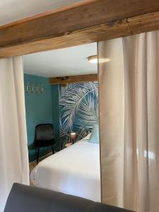 a bedroom with a white bed with a mirror at Lilas, Dahlia, Palme Bleue in Saint-Aignan