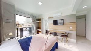Un dormitorio con una cama, una mesa y un televisor. en Residencial Batista, en Bombinhas