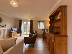 a living room with a couch and a tv at Garfield Place Cosy 2-Bedroom Cottage Central Windsor with Parking in Windsor