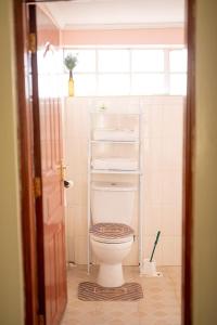 a bathroom with a white toilet in a room at Teresita Home JKIA in Nairobi +108 photos