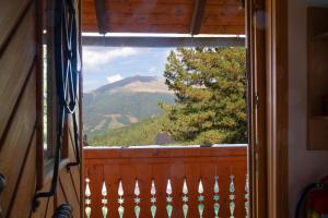 una finestra con vista sulle montagne da una cabina di Idyllische Zirbenholz Alpin Huette a Turracher Hohe