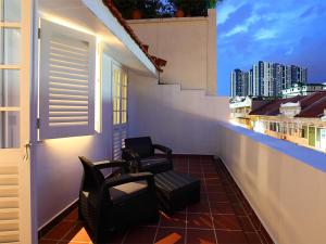 Duas cadeiras numa varanda com vista para a cidade em Arcadia Hotel em Singapura