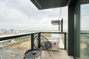 a balcony with a fan and a view of a city at Skyline Black - Cortina North in Voluntari
