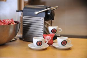 three coffee cups on a counter with a coffee maker at Apartman Family Konaci in Kopaonik +7 photos