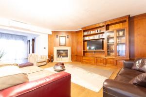 Una sala de estar con un sofá y un televisor. en Villa Adige Luxury - M&M Holiday House, en Perugia