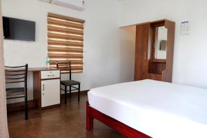 a bedroom with a bed and a desk and a chair at Riverview villa in Alleppey +9 photos
