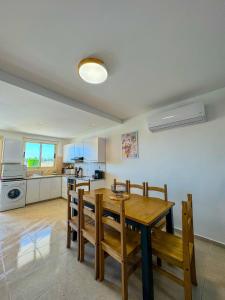 a kitchen and dining room with a wooden table and chairs at Royal-seacrest Oasis, Pool-side in Paphos City