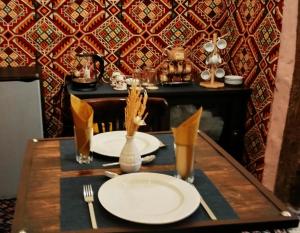 a table with plates and utensils on top of it at Grandma's house in Wadi Musa