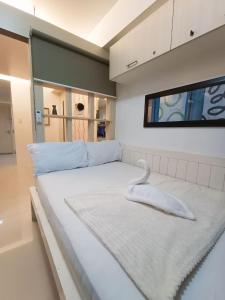 - un lit blanc avec une serviette blanche dans l'établissement Sea Residences Moa Pasay City - Dar Condotel, à Manille