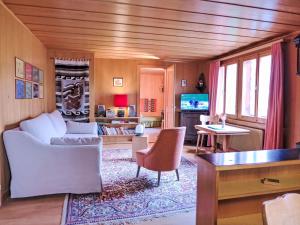 Apartment Chalet Colette-2 by Interhome في جريندلفالد: غرفة معيشة بها أريكة وطاولة