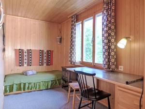 Apartment Chalet Colette-2 by Interhome في جريندلفالد: غرفة بها مكتب وسرير ونافذة