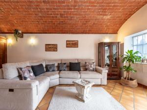 a living room with a couch and a brick wall at Apartment Viola by Interhome in CastellʼAlfero