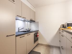 シャンペリーにあるApartment Grand-Pré A by Interhomeの白いキャビネットとシンクのあるキッチン