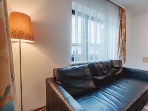 een leren bank in een kamer met een raam bij Apartment Landhaus St- Georg-3 by Interhome in Bad Gastein