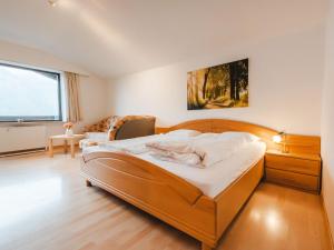 een slaapkamer met een groot bed met een houten hoofdeinde bij Apartment Landhaus St- Georg-8 by Interhome in Bad Gastein