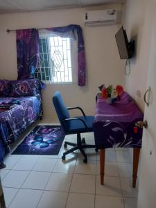 a room with a chair and a table and a window at Holiday rooms in St Thomas Jamaica in Clifton