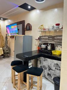 a kitchen with a black table and two stools at Modern Moroccan apartment near the beach in Safi in Safi