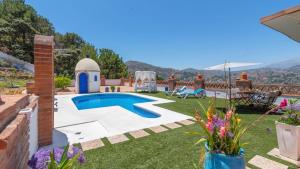 a garden with a swimming pool and a patio at Villa Manolo Torrox by Ruralidays in Torrox