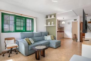 a living room with a blue couch and a table at La Casa de Maika in Guatiza