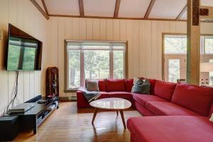 a living room with a red couch and a tv at View and access to Lake Orford - Spa - Australe in Austin