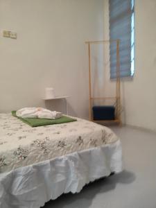 a bedroom with a bed with a white comforter and a window at SS HOMESTAY - Homestay Budget Tanah Merah in Tanah Merah