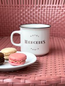 a cup of coffee and cookies on a table at Hôtel Mercedes in Paris +36 photos