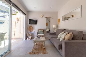 una sala de estar con un sofá y una mesa en Central Los Gigantes Florida By Dreamhomestenerife, en Acantilado de los Gigantes