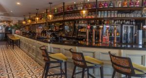 a bar with chairs and a counter with liquor bottles at The Bold Hotel; BW Signature Collection in Southport