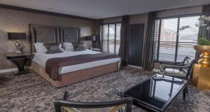 a bedroom with a large bed and a table and chairs at The Bold Hotel; BW Signature Collection in Southport